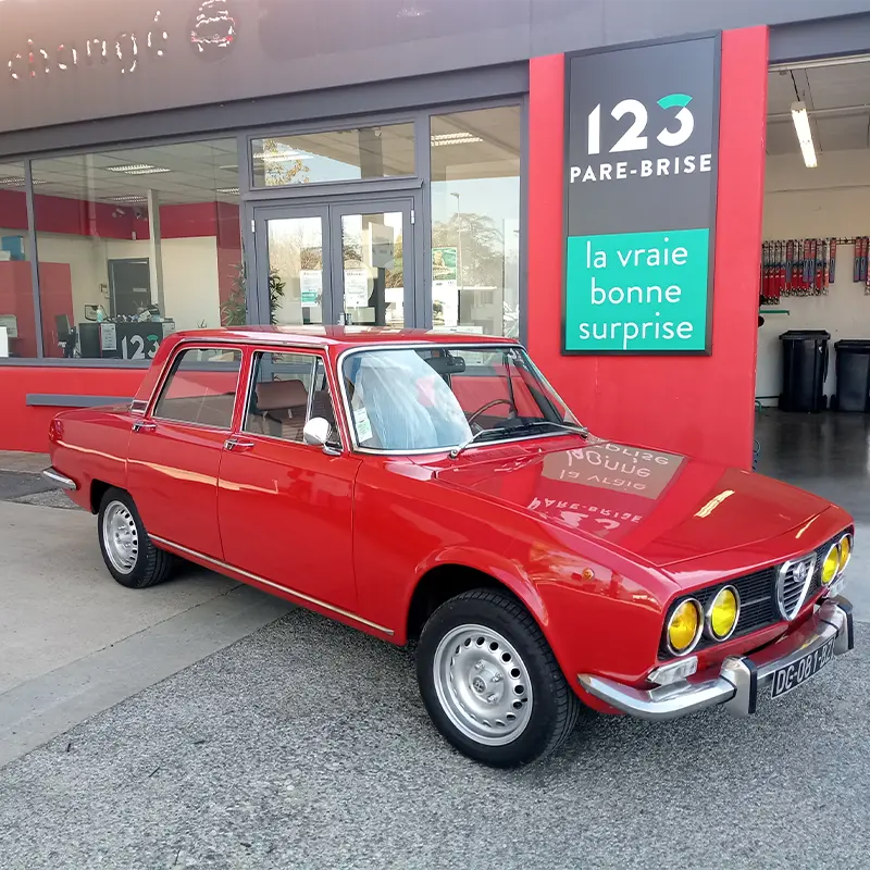 Une Alfa Romeo Berlina 2000 devant le centre 123 Pare-Brise Romans-sur-Isère.